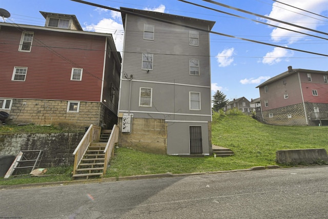 rear view of house with a yard and stairway