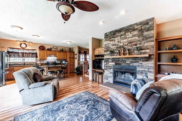 1252 Monumental Rd, Fairmont, WV 26554 - living room featuring a ceiling fan, a textured ceiling, light wood finished floors, and a healthy amount of sunlight