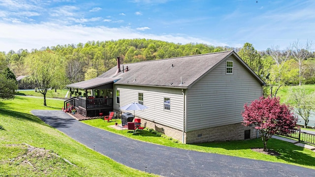 1252 Monumental Rd, Fairmont, WV 26554 - view of property exterior with a lawn, a forest view, roof with shingles, and crawl space