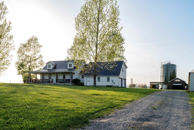 cape cod-style house with a porch, metal roof, and a front lawn