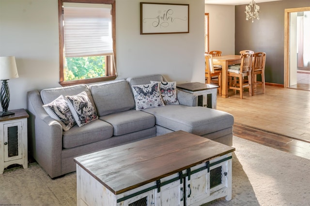living area featuring light wood-type flooring and a notable chandelier