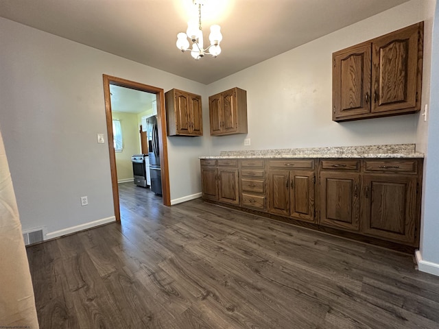 kitchen with dark wood-style flooring, baseboards, an inviting chandelier, and stainless steel appliances