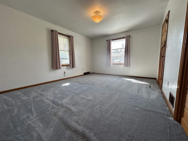 spare room with visible vents, carpet flooring, and baseboards