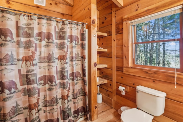 79 Pines Dr, Davis, WV 26260 - bathroom with visible vents, wood finished floors, toilet, wooden walls, and a shower with shower curtain