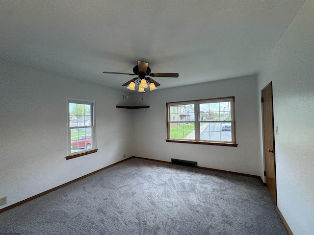 unfurnished room featuring carpet floors, a ceiling fan, baseboards, and visible vents