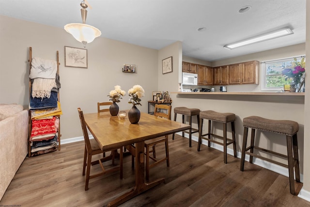 dining space featuring baseboards and wood finished floors