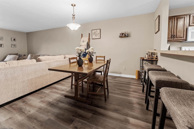 dining space with baseboards and dark wood-style flooring