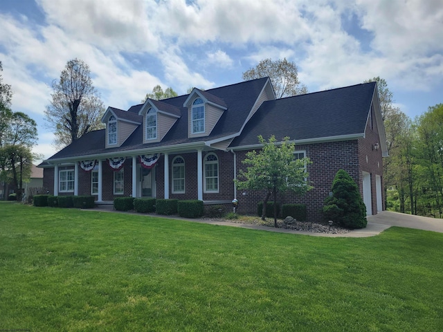 cape cod home featuring concrete driveway, brick siding, and a front lawn