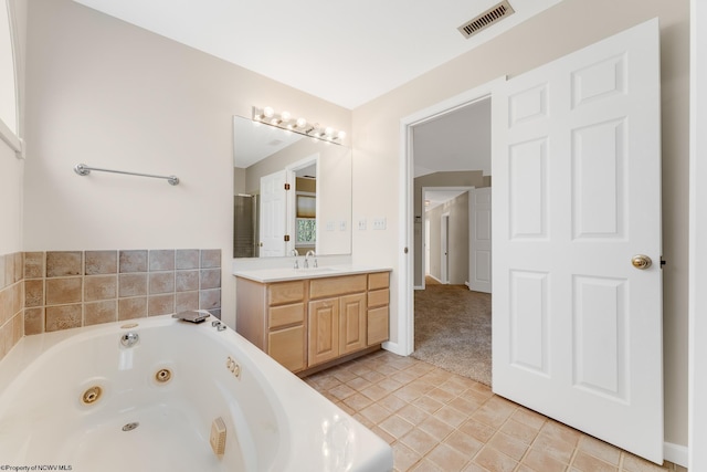 full bath featuring visible vents, tile patterned floors, vanity, and a jetted tub
