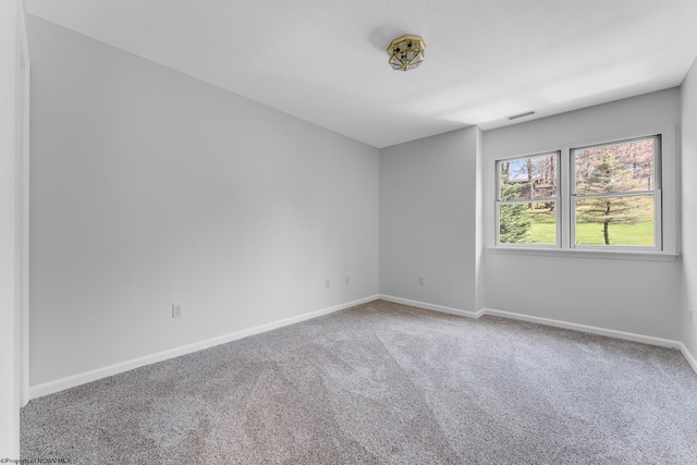 carpeted spare room featuring visible vents and baseboards