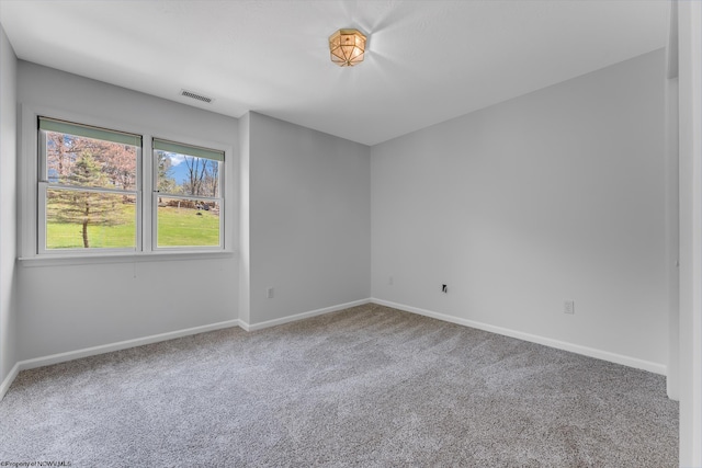 carpeted empty room featuring visible vents and baseboards