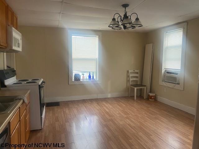 510 6th St, Fairmont, WV 26554 - unfurnished dining area featuring baseboards, light wood finished floors, cooling unit, and a notable chandelier