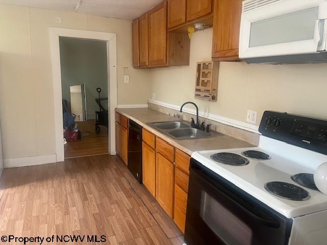 510 6th St, Fairmont, WV 26554 - kitchen with electric range oven, a sink, white microwave, light wood finished floors, and black dishwasher