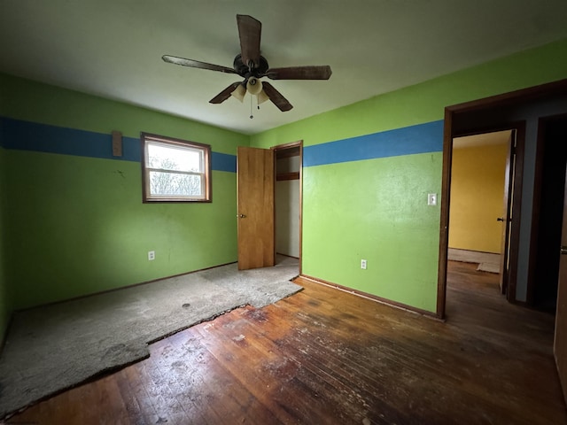 unfurnished bedroom with baseboards, ceiling fan, wood-type flooring, and a closet