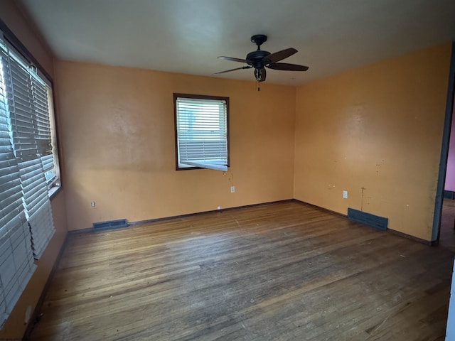 spare room featuring a ceiling fan, wood finished floors, and visible vents