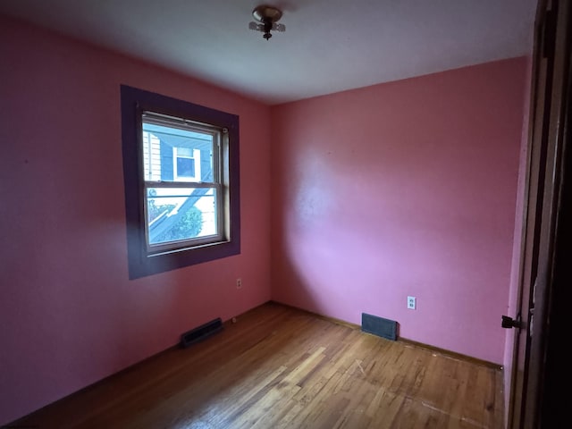 unfurnished room featuring visible vents and wood finished floors