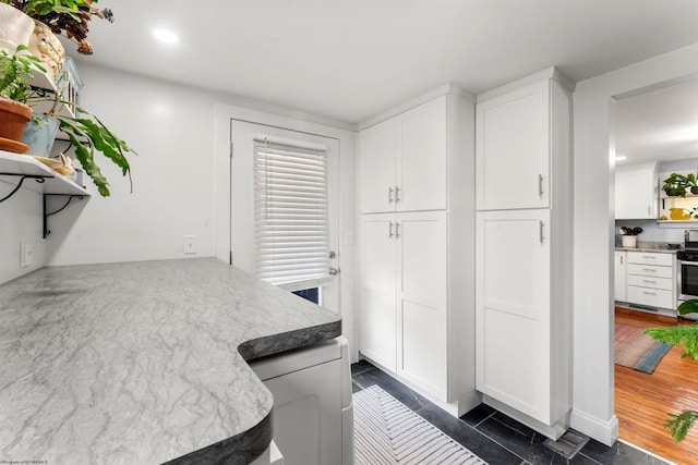 kitchen featuring recessed lighting, open shelves, stainless steel range oven, and white cabinets