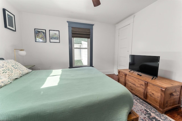 bedroom with baseboards, ceiling fan, and dark wood-style floors