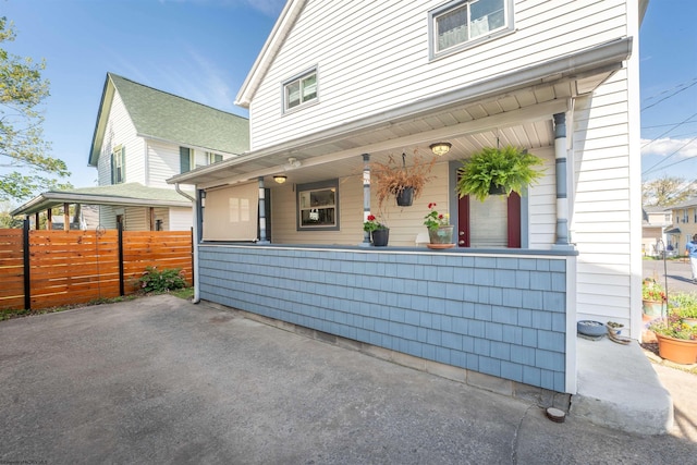 view of front of property with a porch and fence
