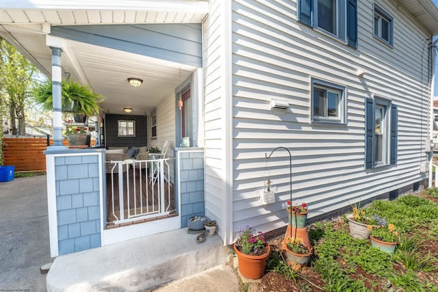 view of property exterior featuring covered porch and fence