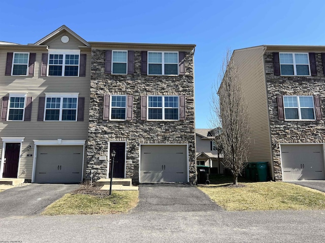 multi unit property featuring driveway and stone siding