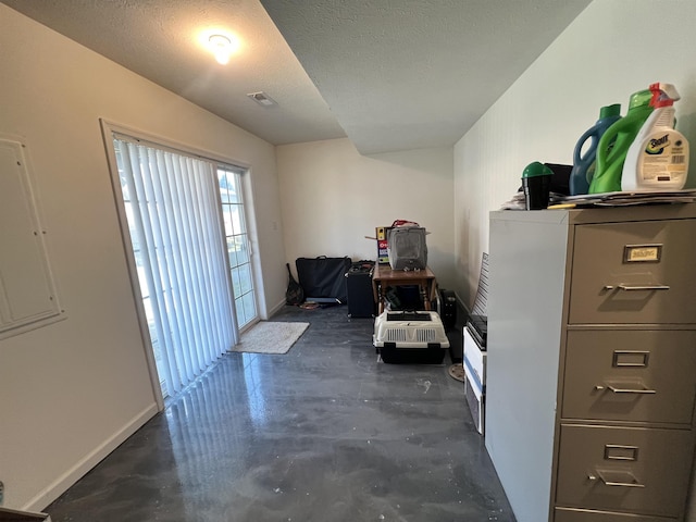 interior space featuring finished concrete floors, a textured ceiling, baseboards, and visible vents