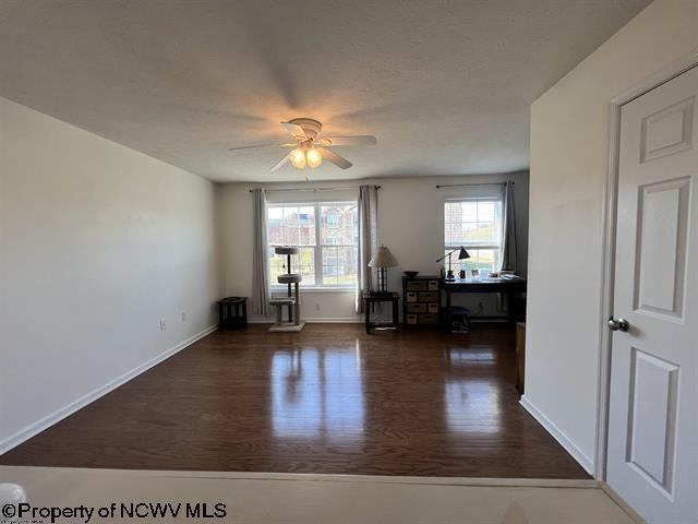 unfurnished room with a ceiling fan, baseboards, and wood finished floors