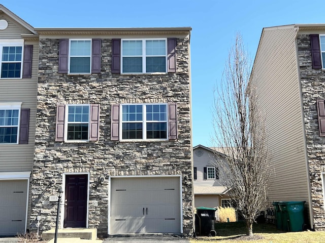 view of property with a garage and stone siding