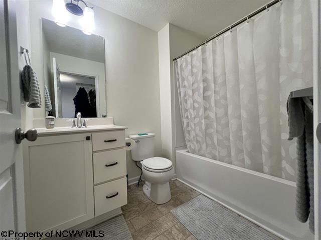 full bath with toilet, a textured ceiling, shower / bath combo with shower curtain, and vanity