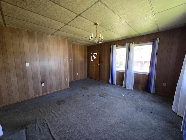 130 Hunsaker St, Fairmont, WV 26554 - unfurnished dining area with an inviting chandelier, wood walls, carpet, and a drop ceiling