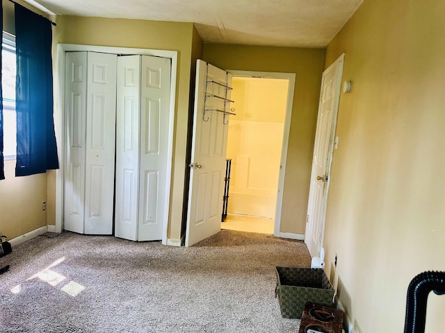 unfurnished bedroom featuring carpet floors, baseboards, and a closet