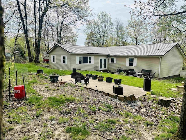 back of house with french doors, a lawn, a patio area, and metal roof