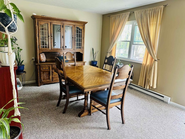 dining room featuring baseboards, baseboard heating, and light carpet