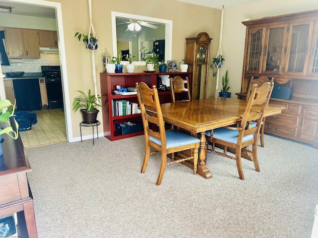dining area featuring a ceiling fan and light carpet