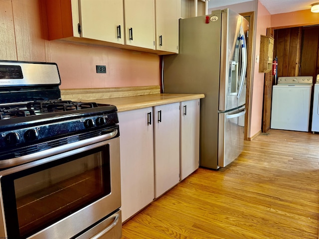 108 Toothman Run Rd, Rivesville, WV 26588 - kitchen with washing machine and dryer, light wood-type flooring, light countertops, stainless steel appliances, and white cabinetry