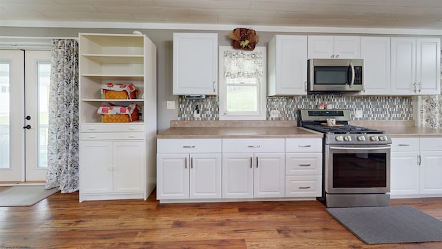 kitchen featuring light countertops, appliances with stainless steel finishes, white cabinets, and light wood-style flooring