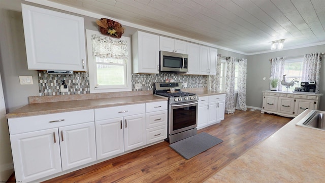 kitchen featuring white cabinetry, appliances with stainless steel finishes, and wood finished floors