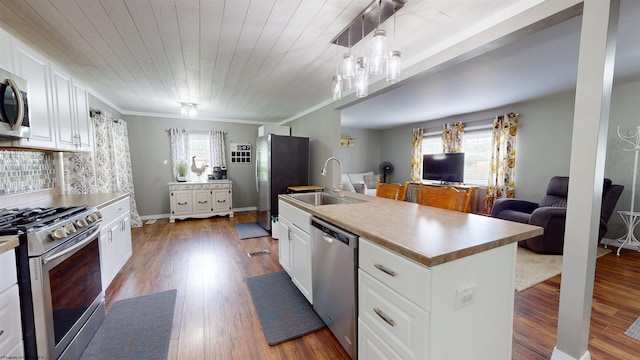 kitchen featuring a sink, appliances with stainless steel finishes, white cabinetry, and wood finished floors