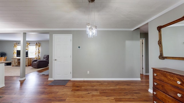 spare room featuring baseboards, ornamental molding, and wood finished floors
