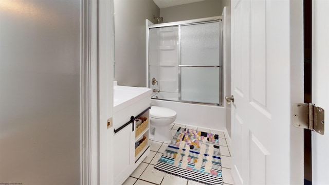 bathroom featuring tile patterned floors, bath / shower combo with glass door, vanity, and toilet