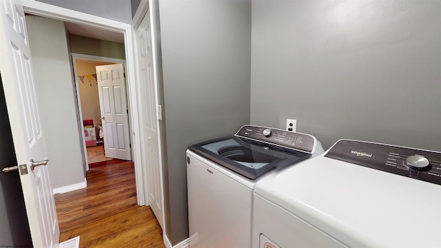 washroom with laundry area, light wood finished floors, and independent washer and dryer