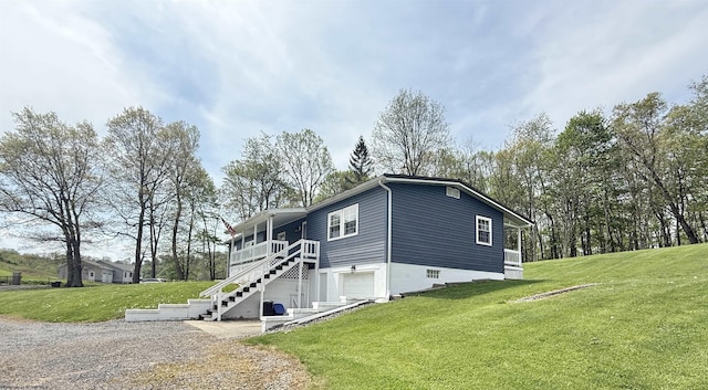 view of property exterior with a yard, driveway, and stairway