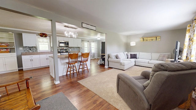 living room with wood finished floors and a notable chandelier