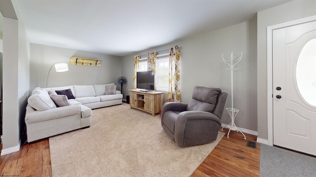 living area with baseboards, wood finished floors, and visible vents