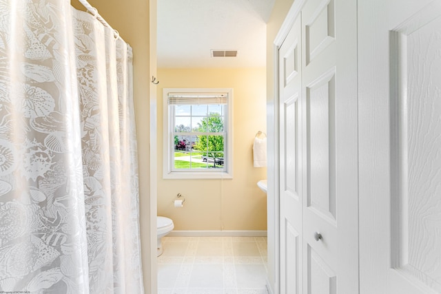 bathroom with toilet, baseboards, visible vents, and curtained shower