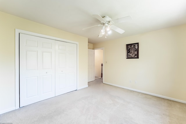 unfurnished bedroom with a closet, baseboards, ceiling fan, and light carpet