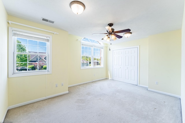 unfurnished bedroom with baseboards, visible vents, carpet, and a closet