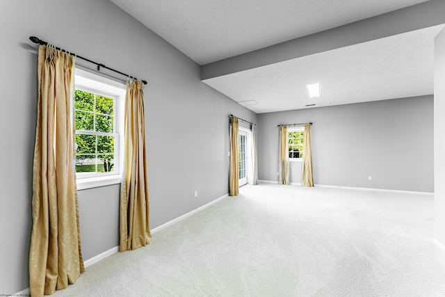 spare room with baseboards, a wealth of natural light, and carpet