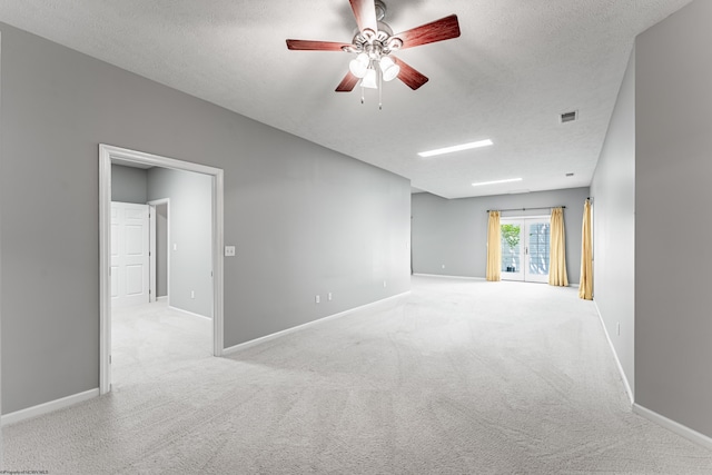 carpeted empty room with baseboards, ceiling fan, a textured ceiling, and visible vents