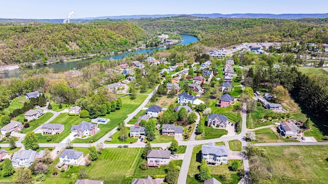 drone / aerial view featuring a water view, a residential view, and a forest view